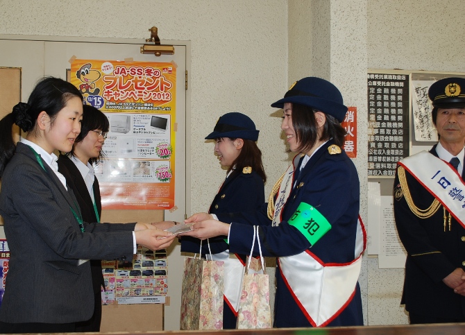 防犯を呼びかけるチラシを配る一日女性警察官